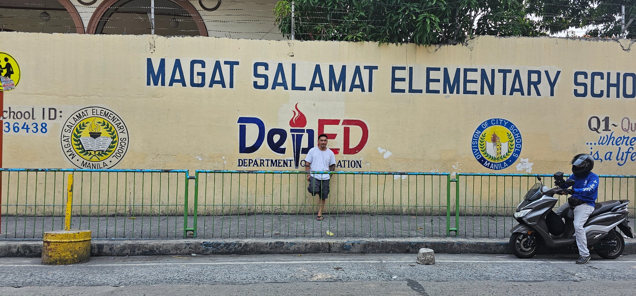 Romeo standing outside the Magat Salamat Elementary School wall during his 2024 return visit.